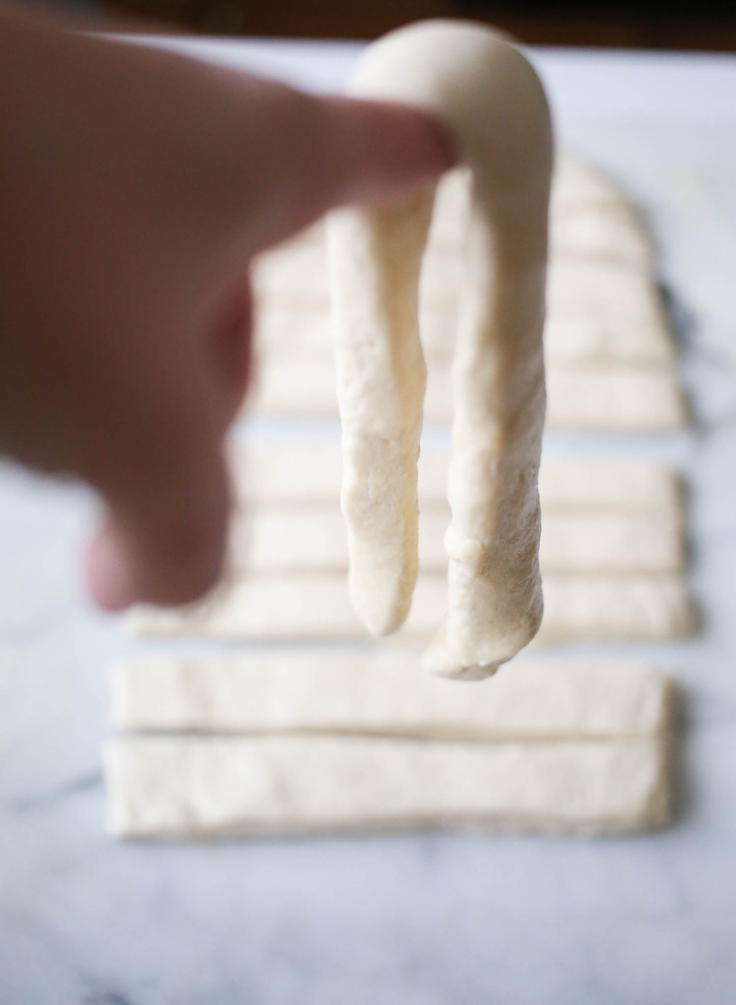 draping dough over finger for breadsticks from our best bites