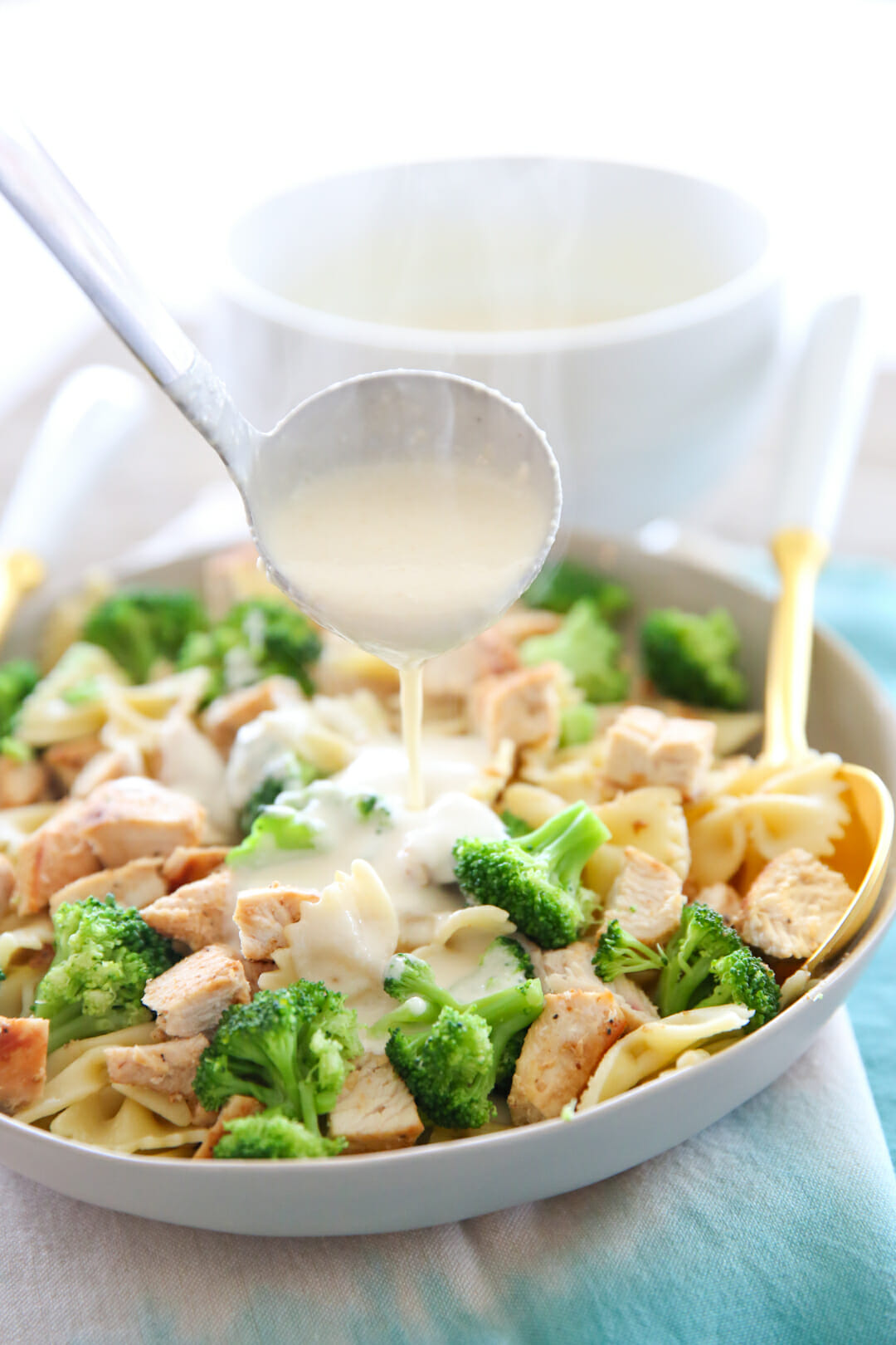 Pouring Alfredo Sauce over Pasta