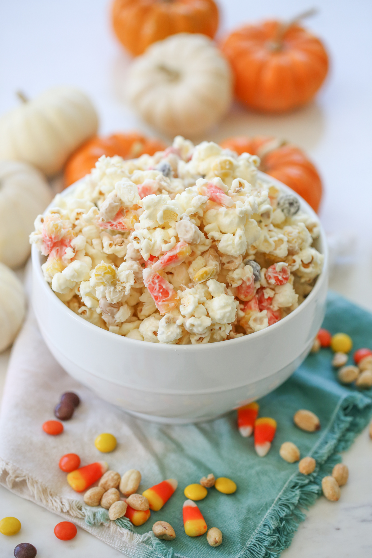 Halloweeen Popcorn in a bowl surrounded by pumpkins