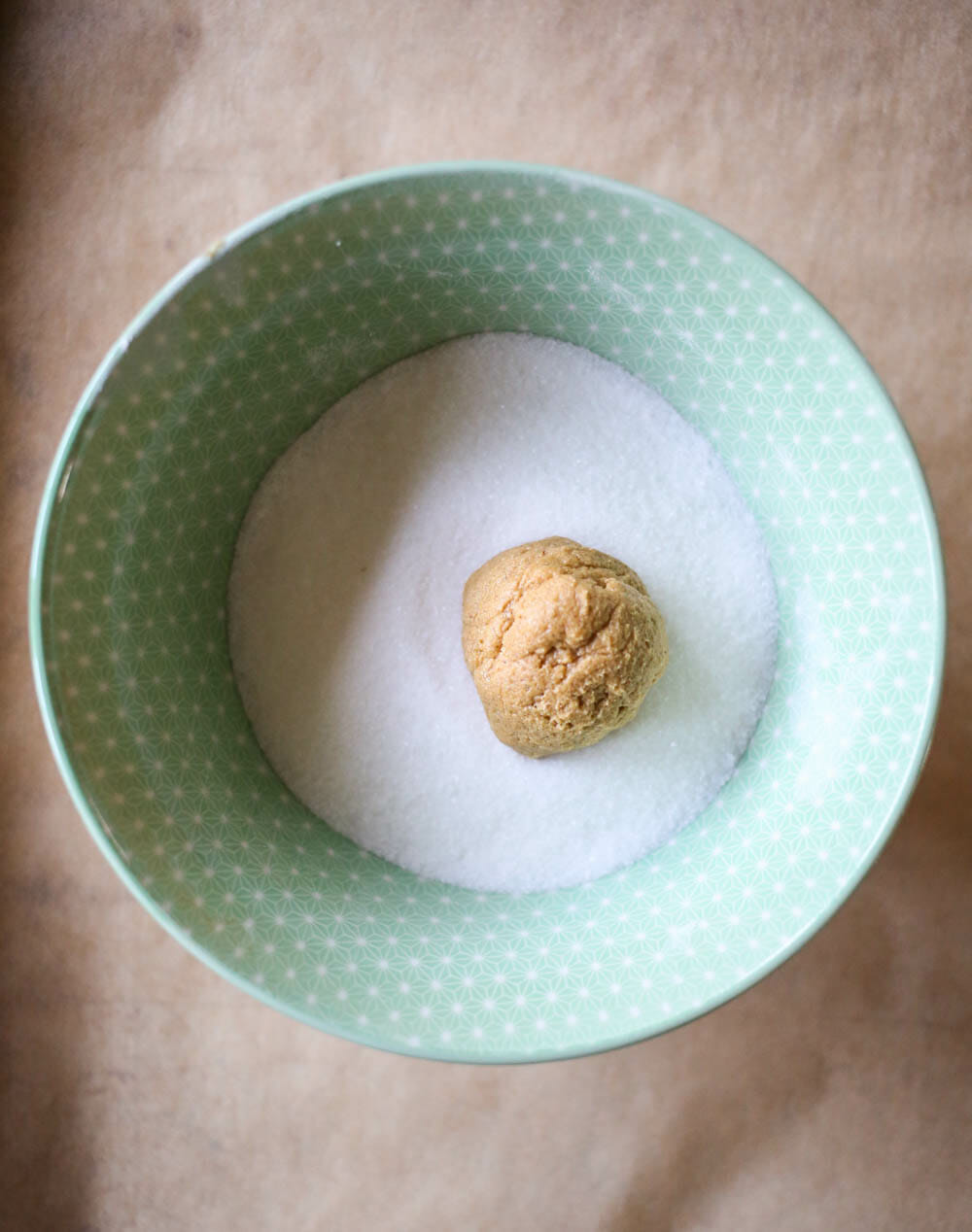 rolling ginger spice cookie dough in sugar