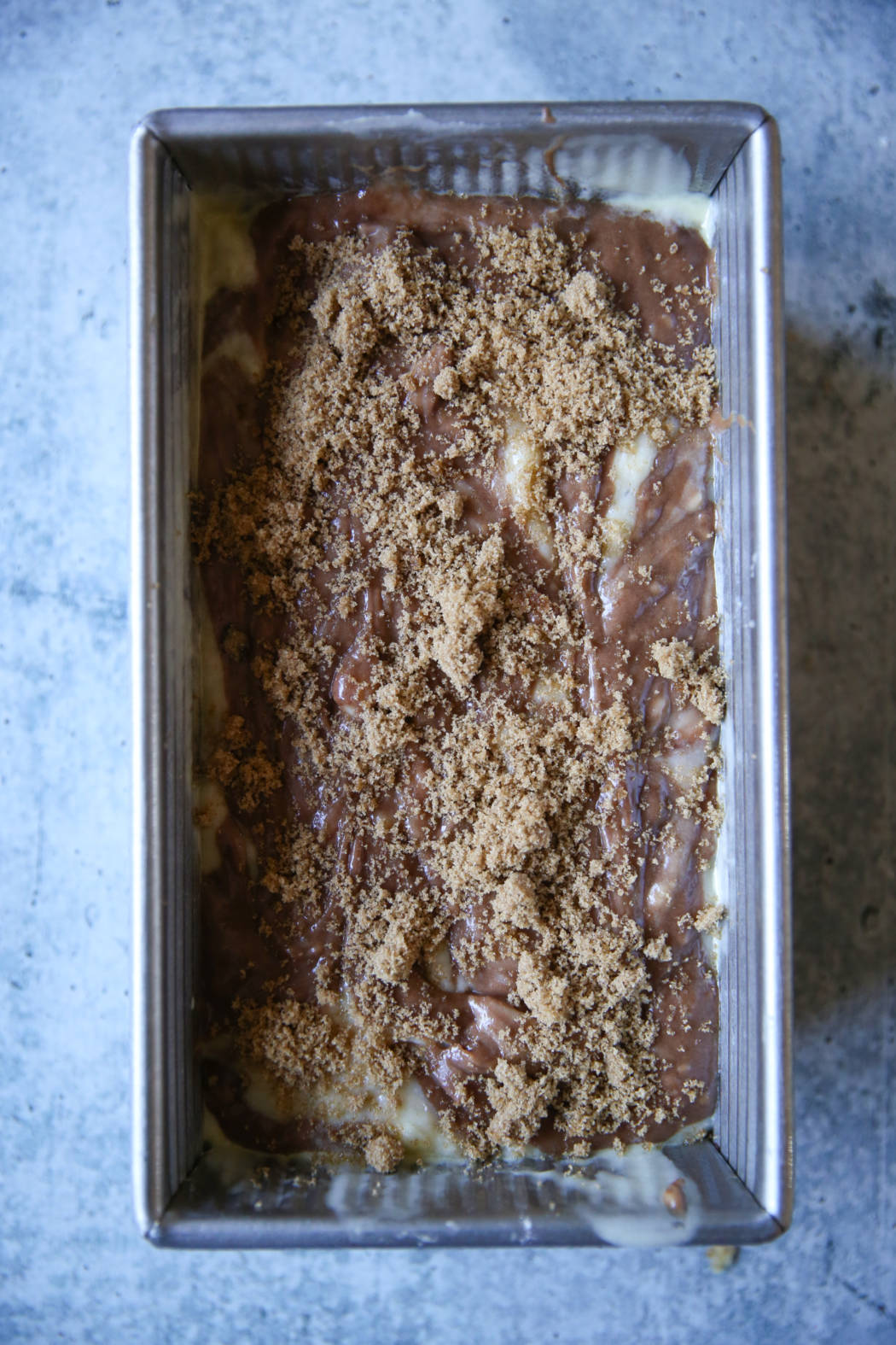 sprinkling brown sugar on chocolate swirled banana bread