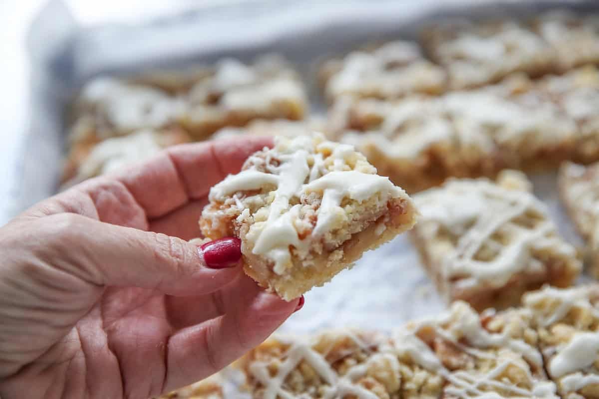 sliced apple streusel bars being held in a hand