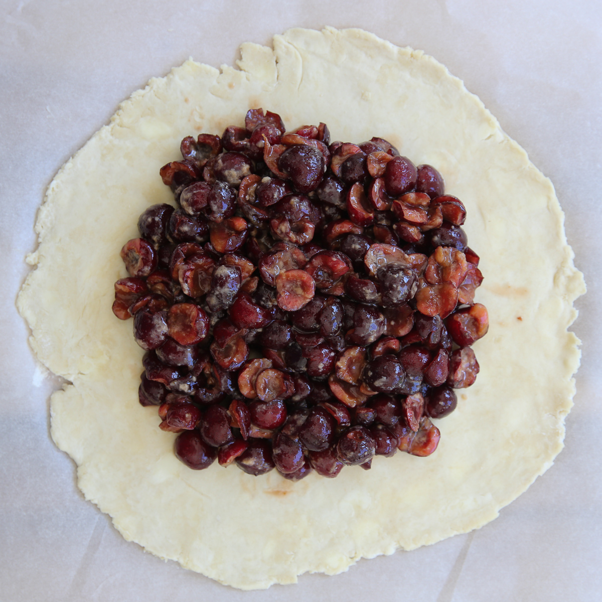 placing chopped fruit filling on a pie crust