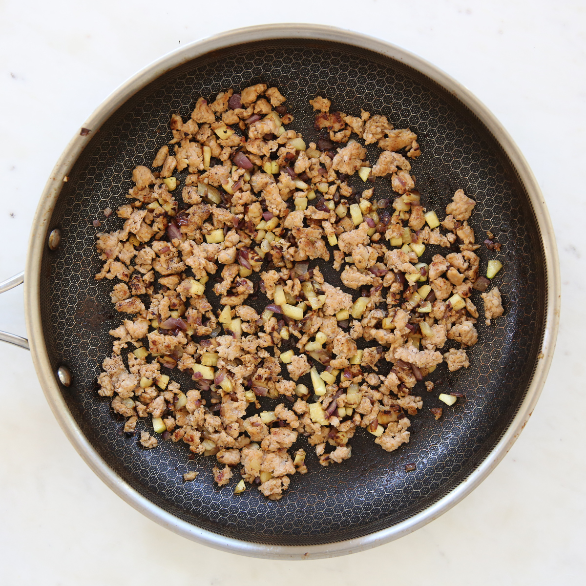 Cooked sausage and tomato in a skillet