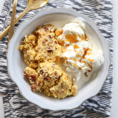 pumpkin dump cake in a white bowl with ice cream