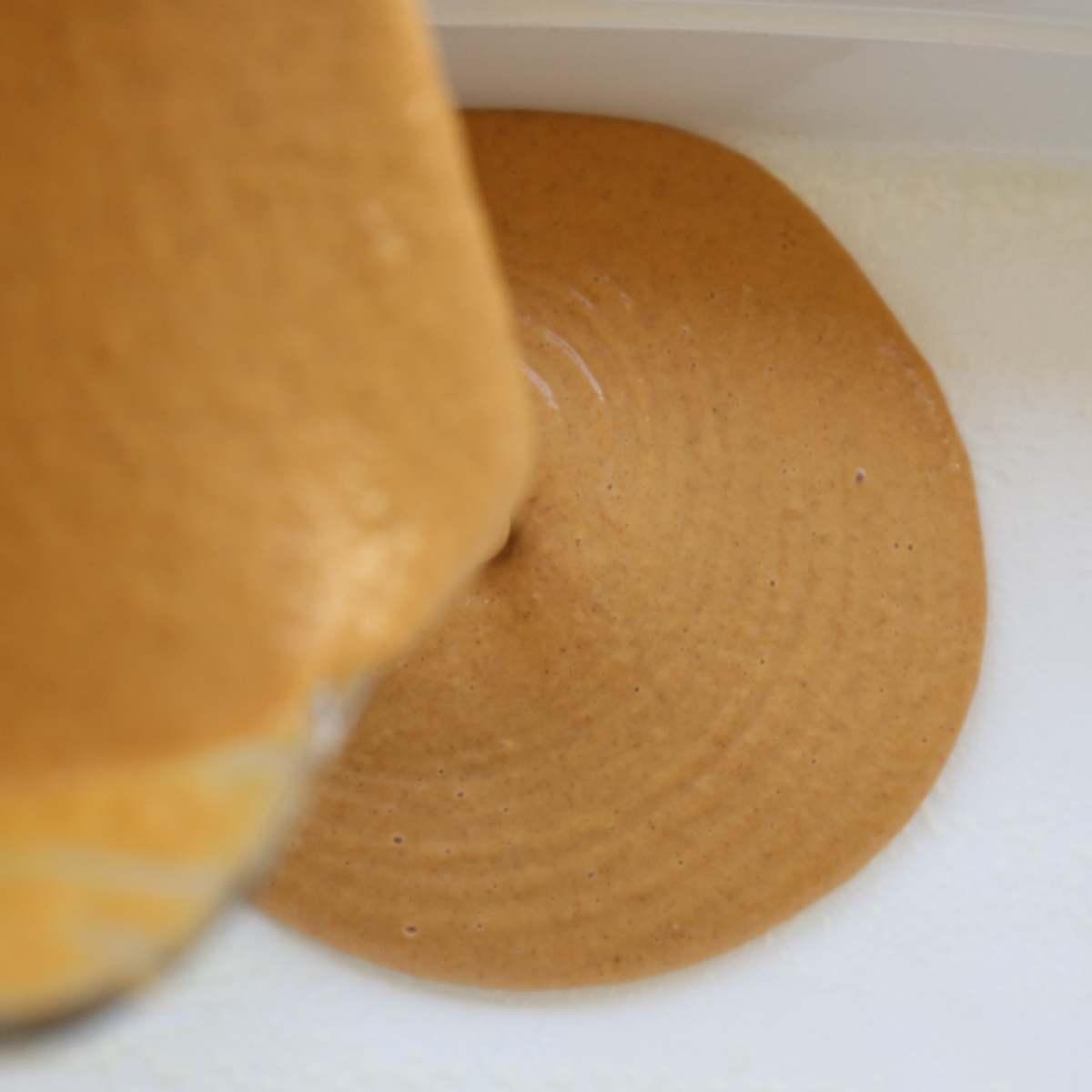 pouring pumpkin batter into a pan