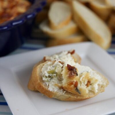 Jalapeno popper dip spread on slices of baguette.