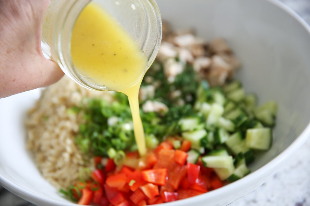 pouring dressing on orzo salad