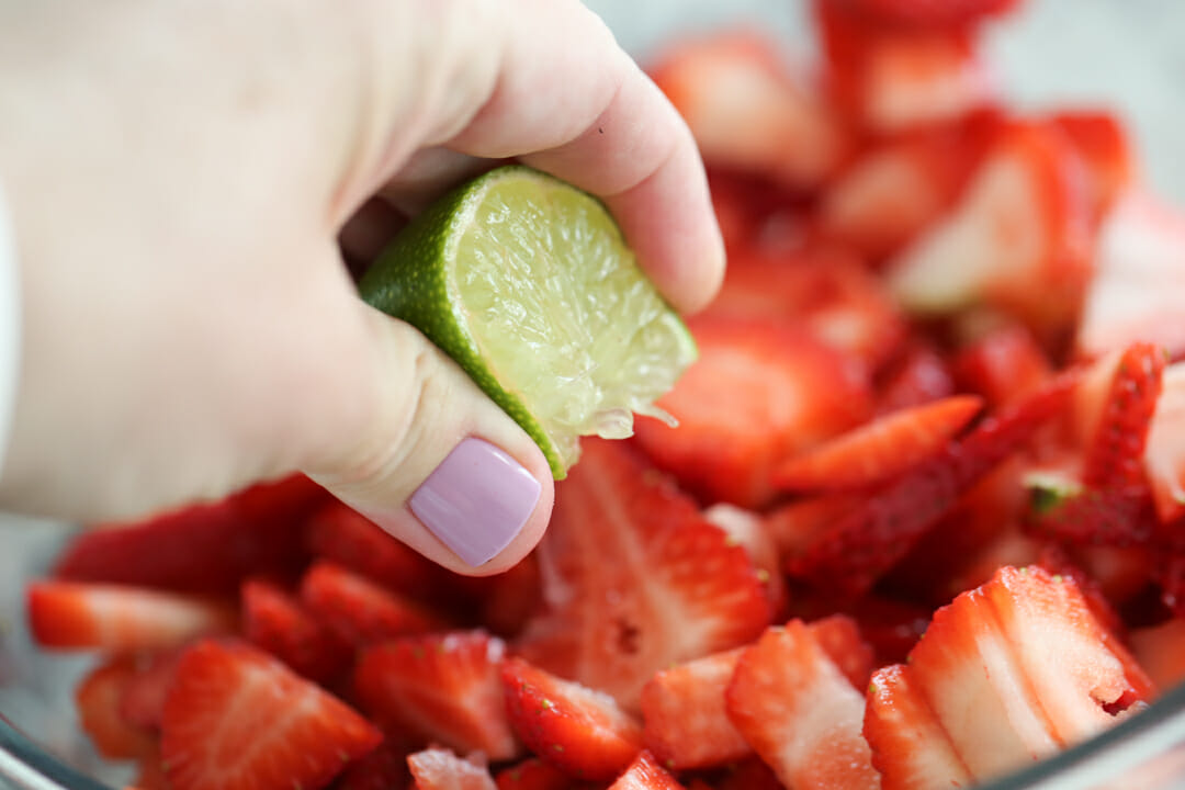 squeezing lime juice in strawberries