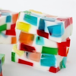 A stack of glass block Jell-O: rectangles of white Jell-O with transparent blocks of colored Jell-O scattered throughout.
