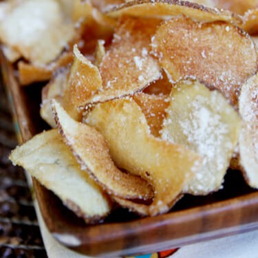 A close up of homemade potato chips in a serving dish.