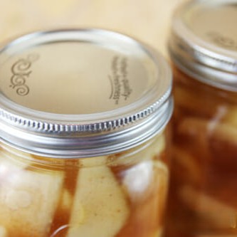 A closeup of a canning jar filled with apple pie filling.