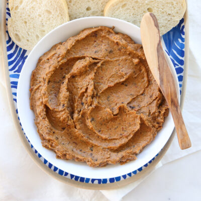 Eggplant spread in a white bowl with a spreader