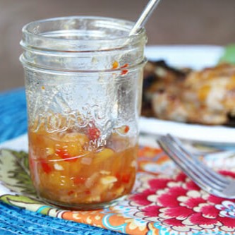 A mason jar of spicy peach bbq sauce