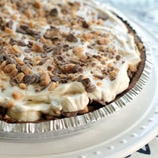A close up of a Dulce de Leche Banana Toffee Pie, with layers of banana, whipped topping, and toffee visible.