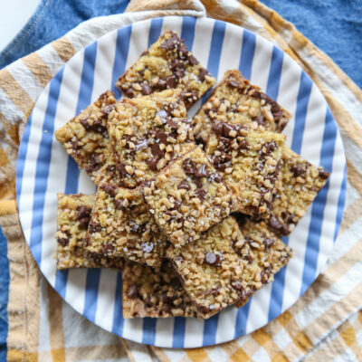 Toffee Chocolate Chip Cookie Bars stacked on a striped plate