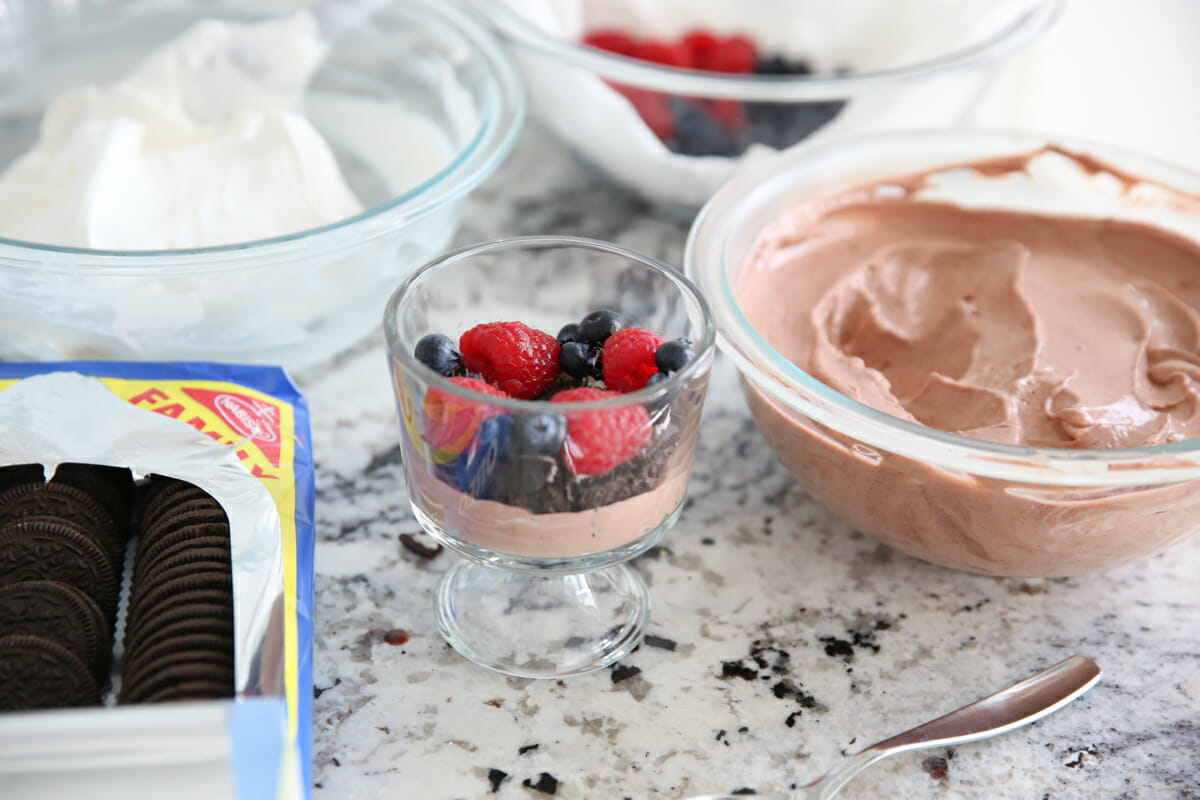 Filling a dessert cowl with chocolate pudding and berries