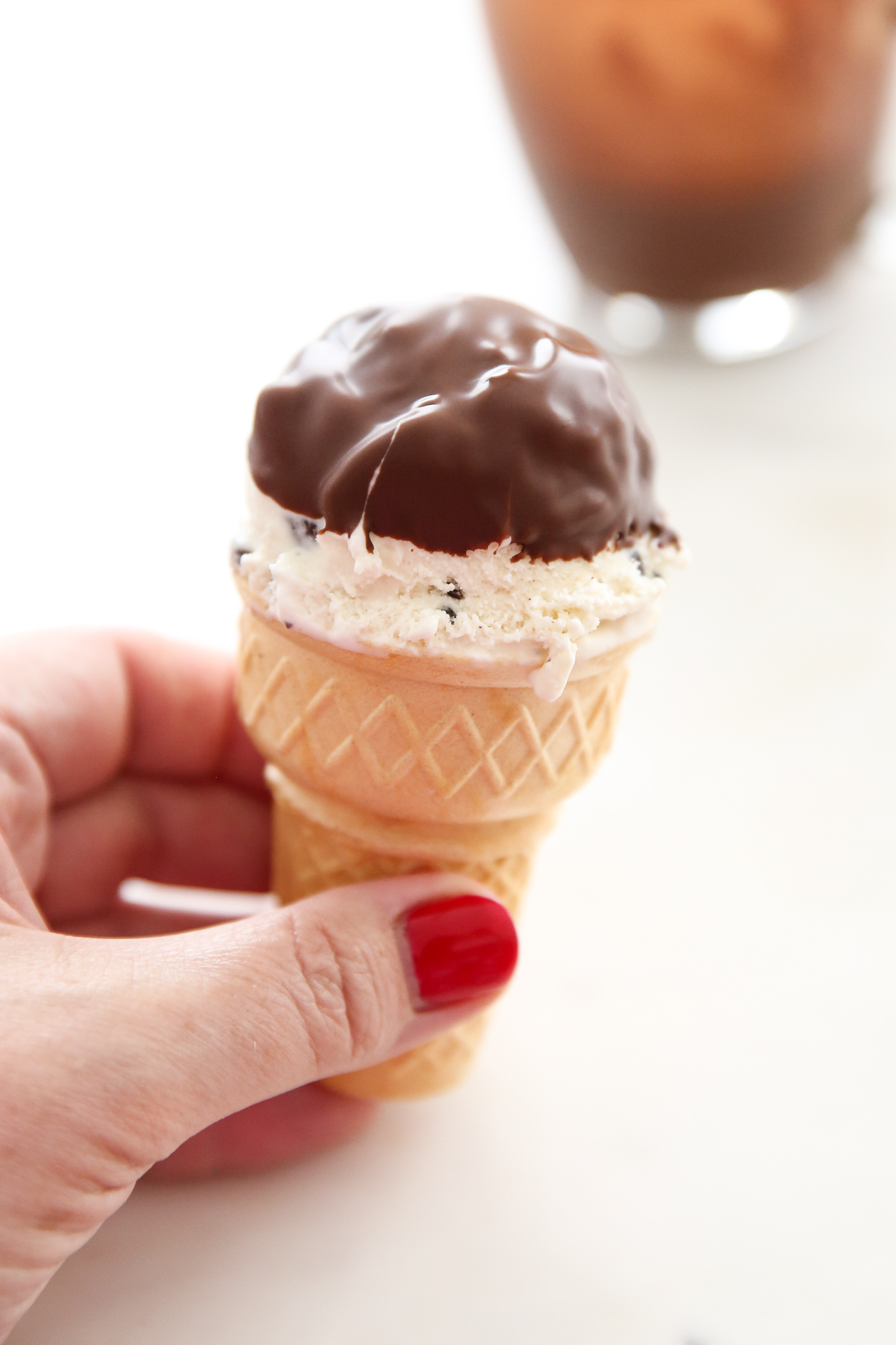 dipping an ice cream cone into melted chocolate