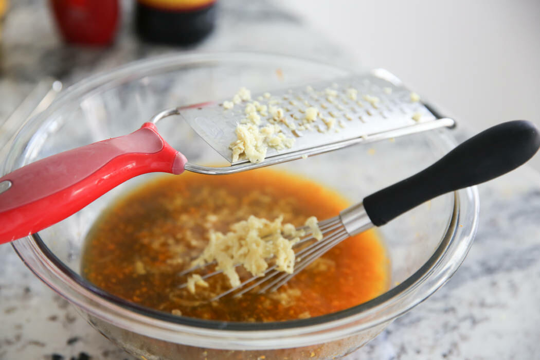 grating fresh ginger into bowl