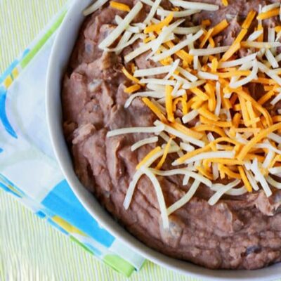 A bowl of refried beans topped with cheese.