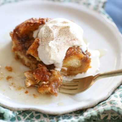 baked square of pumpkin French toast sliced on a plate with whipped cream on top