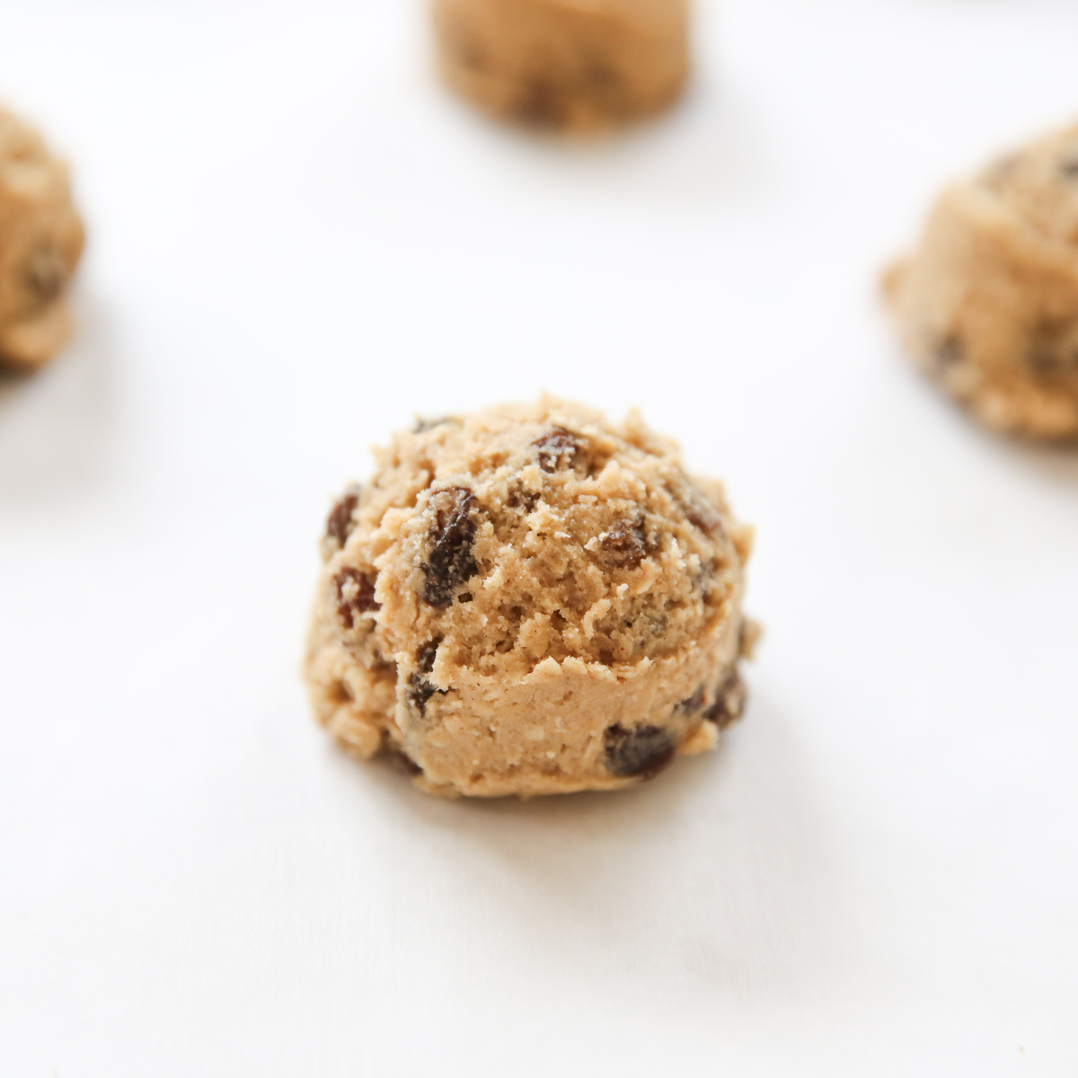 ball of oatmeal raisin cookie on a baking sheet