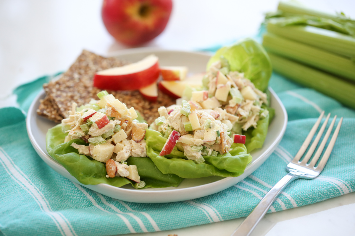 chicken salad in lettuce leaves on a white plate