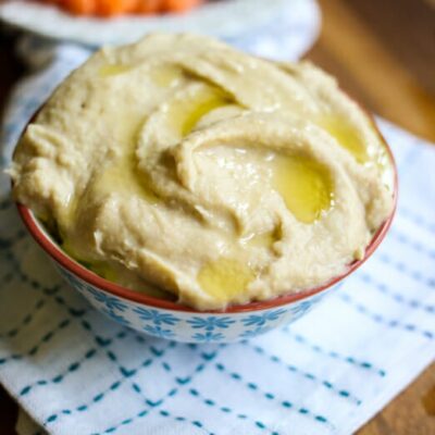 A bowl of hummus, drizzled with olive oil