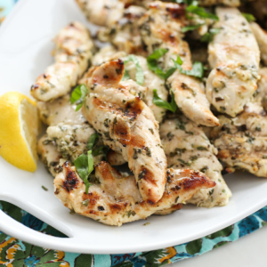 Lemon garlic herb rubbed chicken on a white platter.