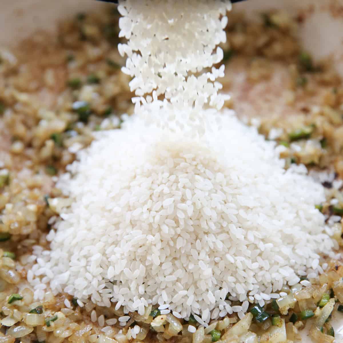 pouring rice into a skillet