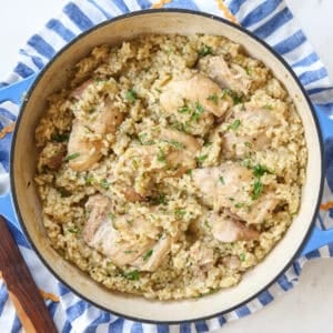 Green chili chicken and rice in a skillet on top of a striped towel