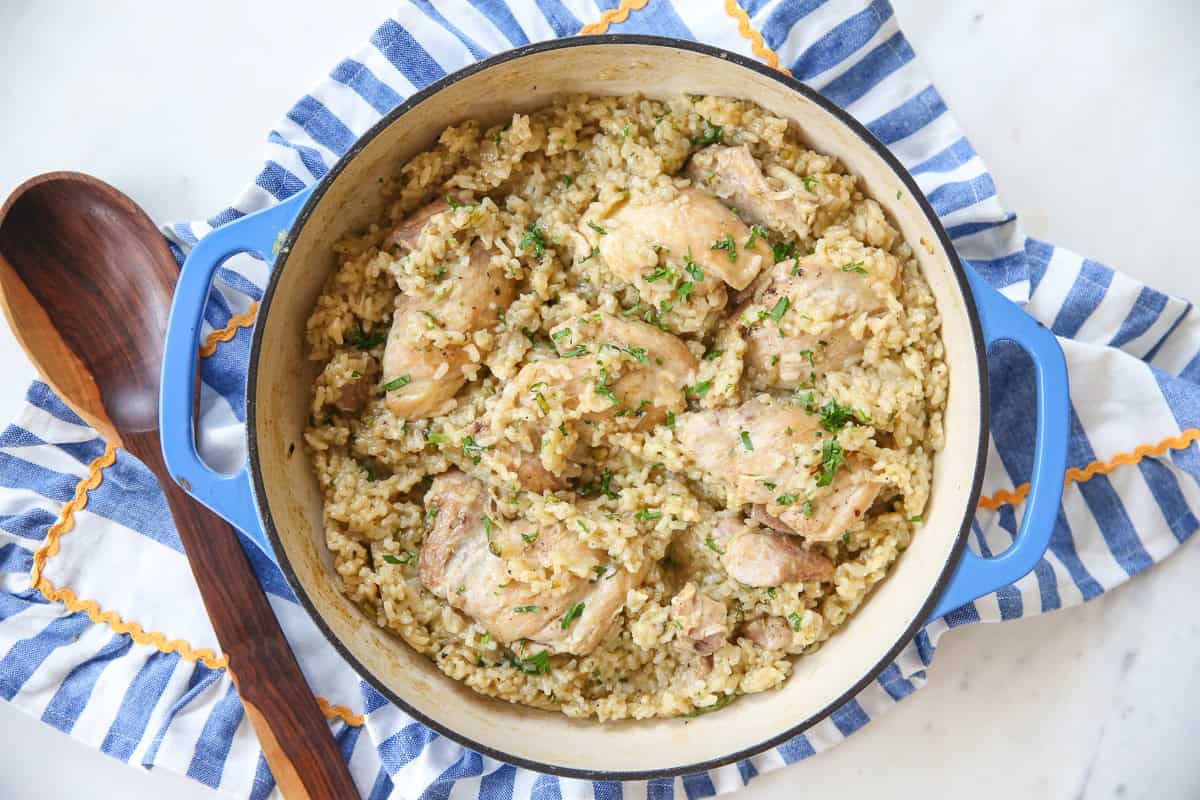 Green chili chicken and rice in a skillet on top of a striped towel