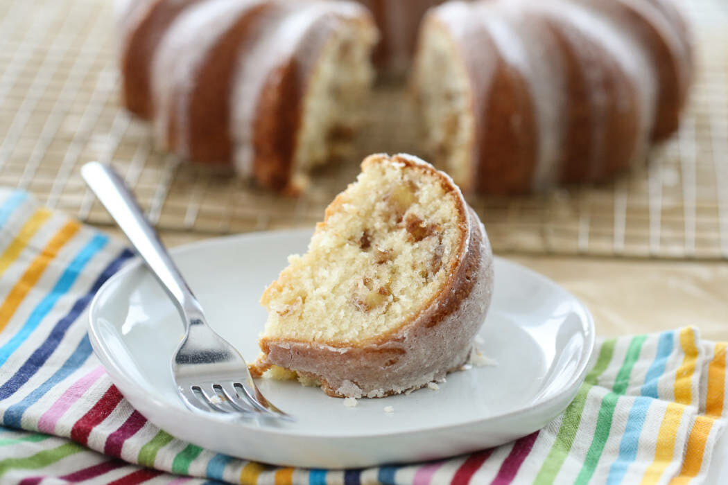 A slice of apple spice bundt cake on a white plate.