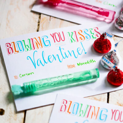 A Valentine card that says, "Blowing You Kisses Valentine" with a tube of bubbles and a few chocolate kisses attached.