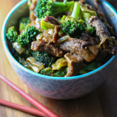 A blue bowl filled with beef and broccoli in a savory Asian sauce.