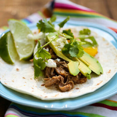 A flour tortilla with smoky pork and avocado.