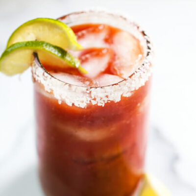 A virgin bloody Mary with lime slices and salt on the rim.