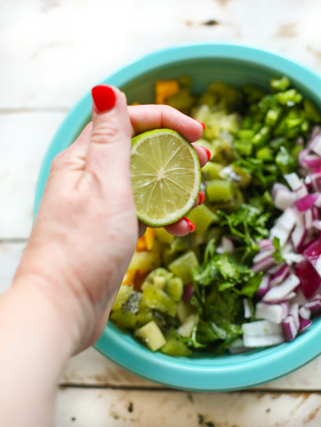 adding lime juice to kiwi mango salsa