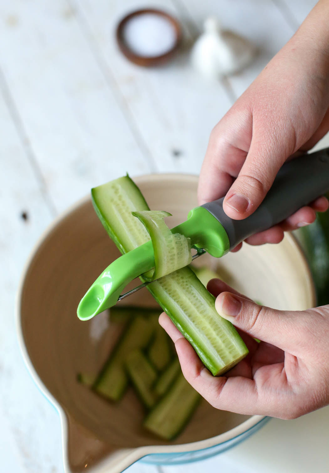 shaving baby cucumbers into ribbons for quick pickles from our best bites