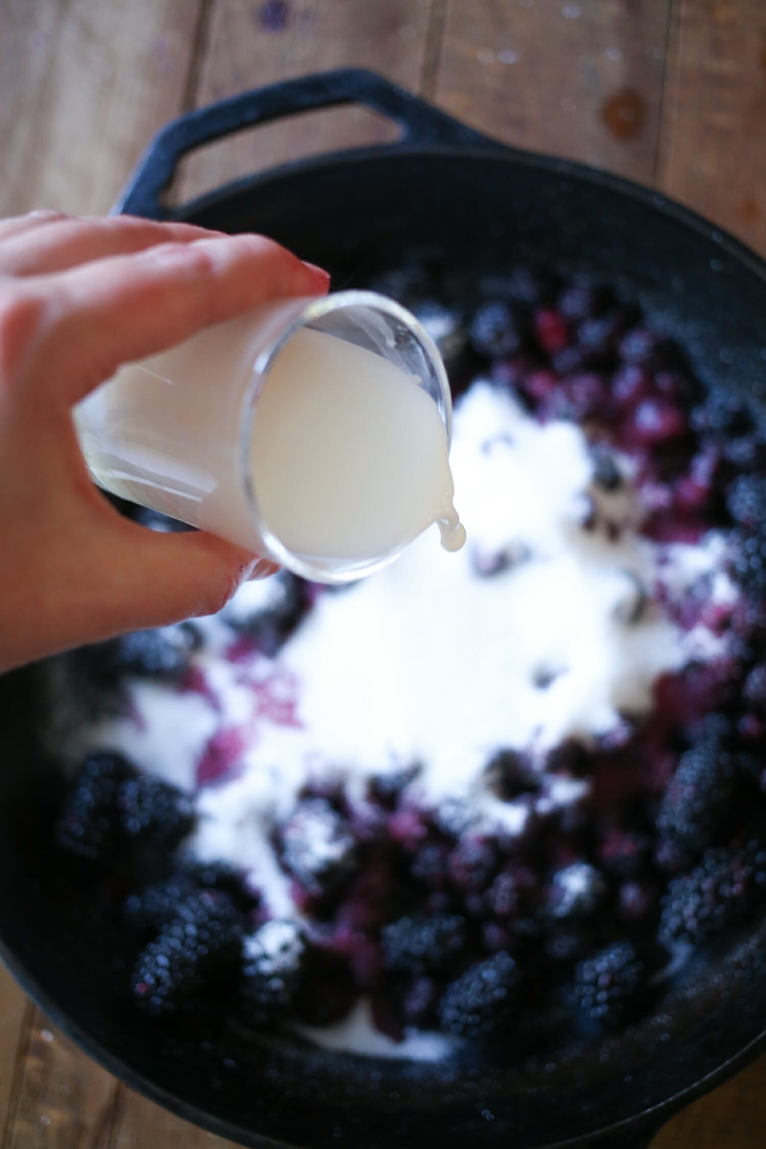 pouring cornstarch and water over blackberries