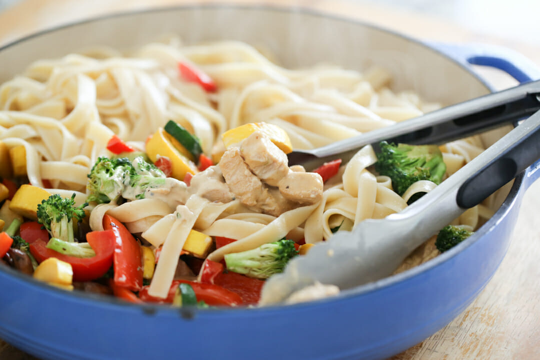 mixing pasta in pan