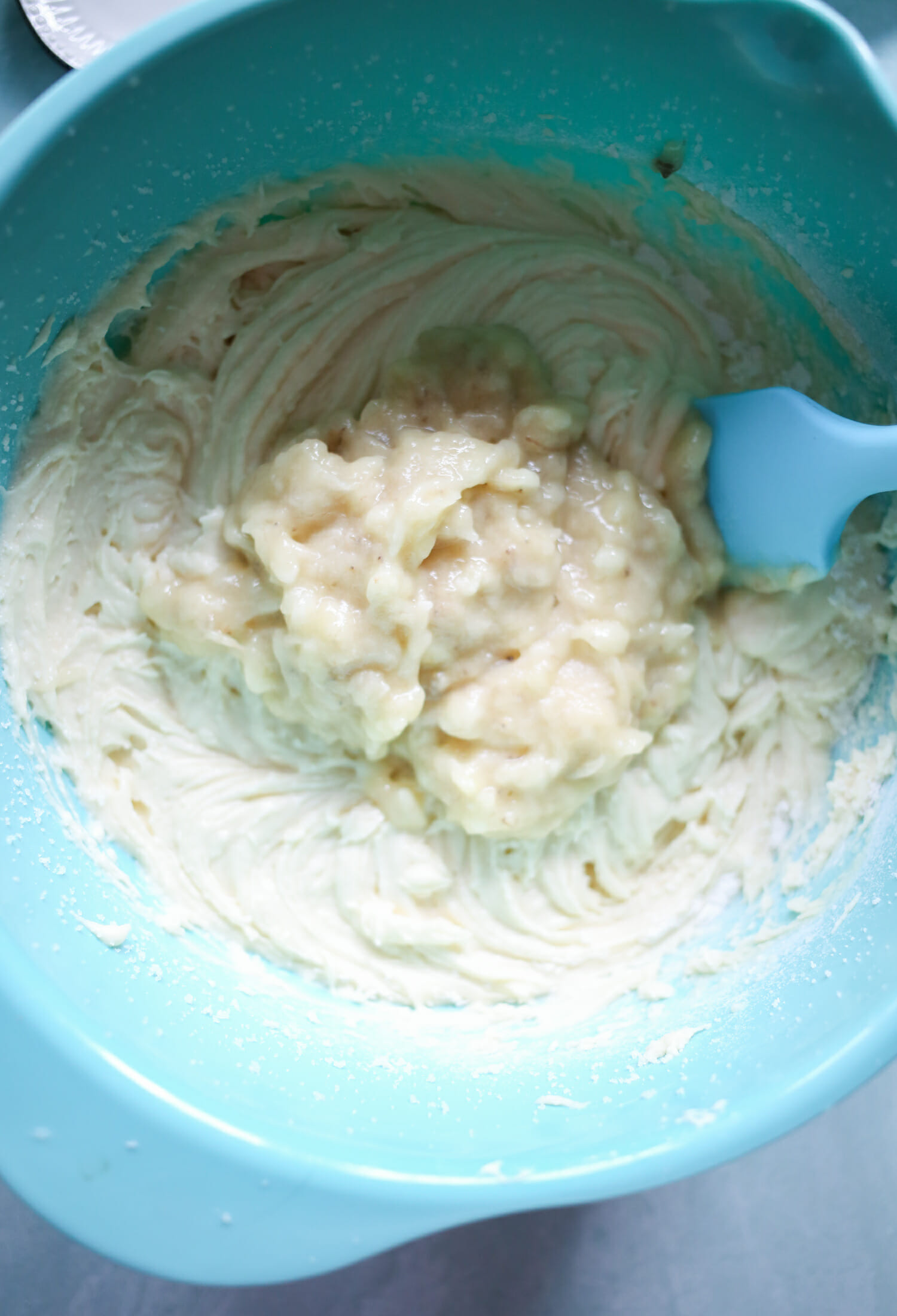 adding banana to batter for banana bars with cream cheese icing from our best bites