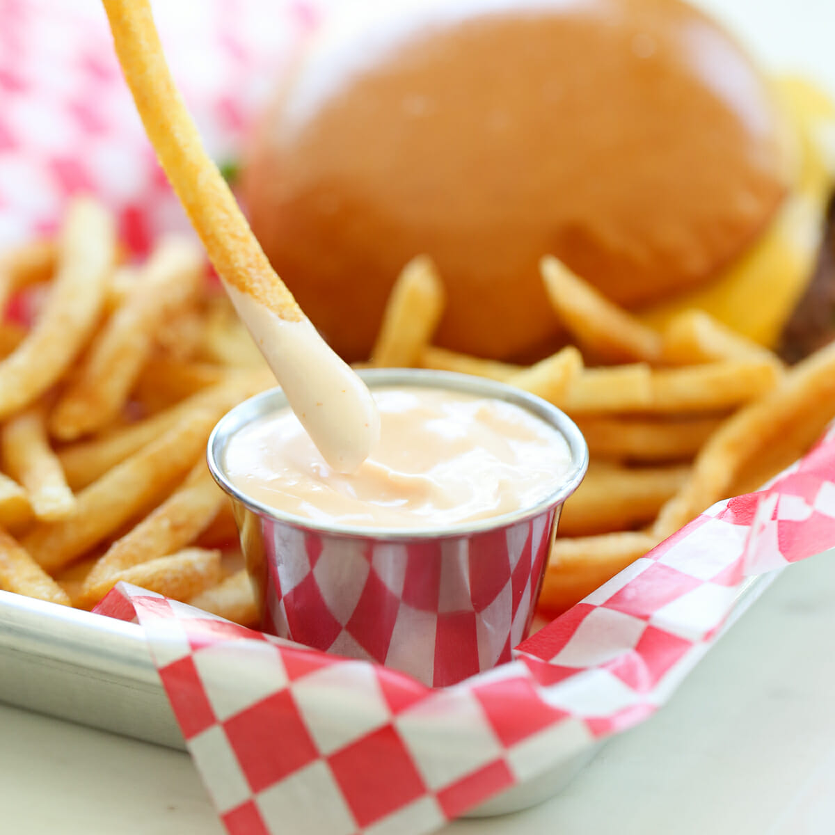 dipping french fry in sauce