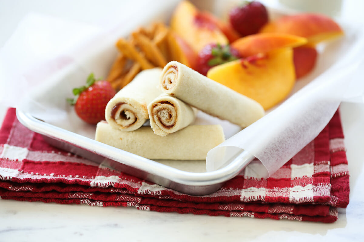 rolled pb and j on a tray with fruit