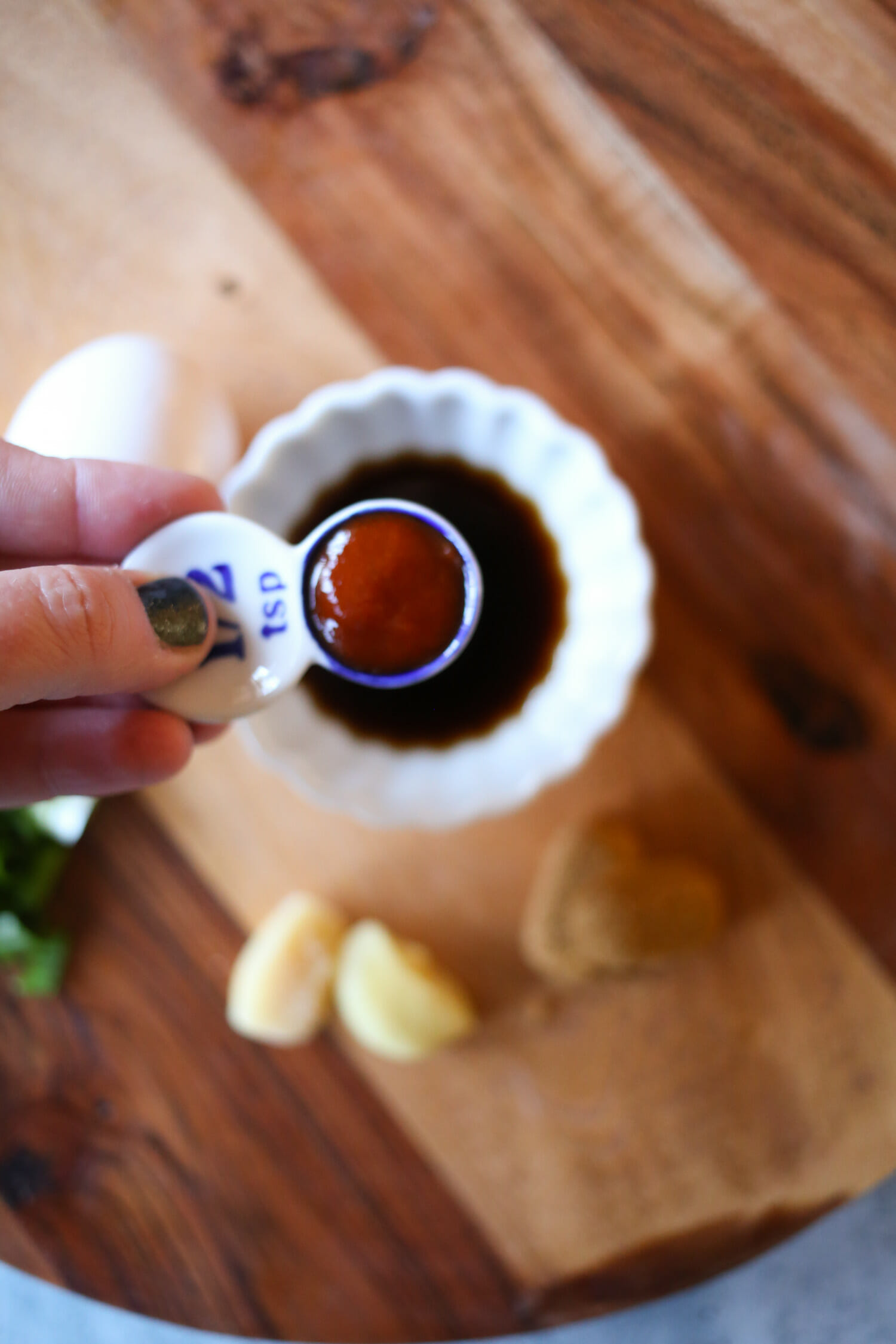 adding Sriracha to a bowl of soy sauce