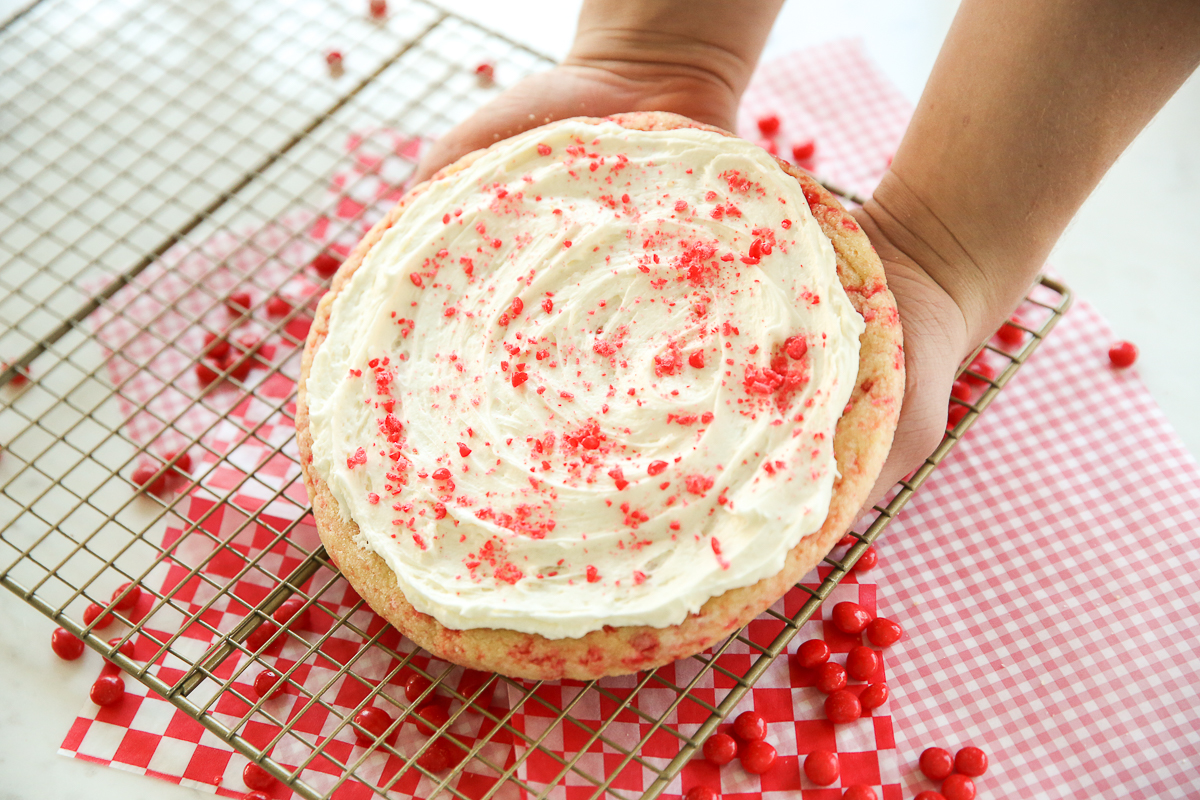 baked red hot sugar cookie in person's hands