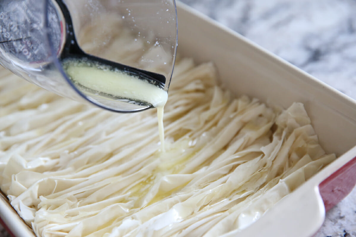 pouring butter over phyllo