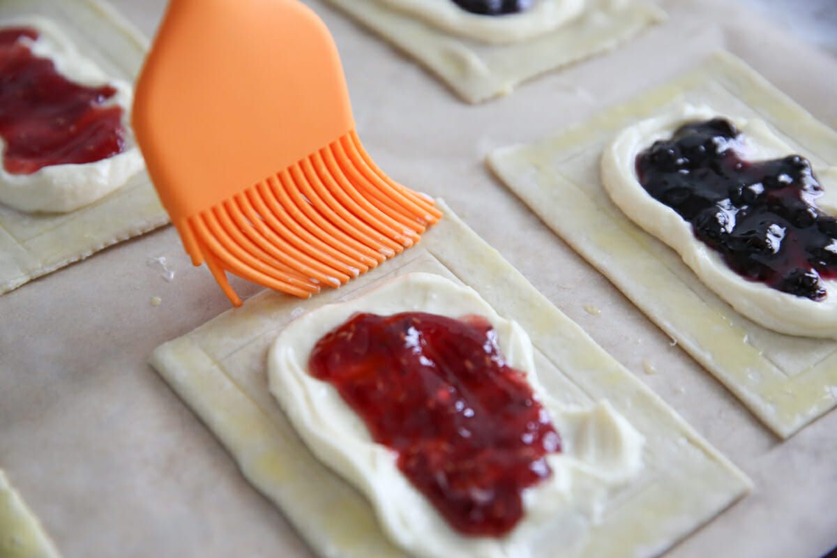 brushing egg wash on pastry