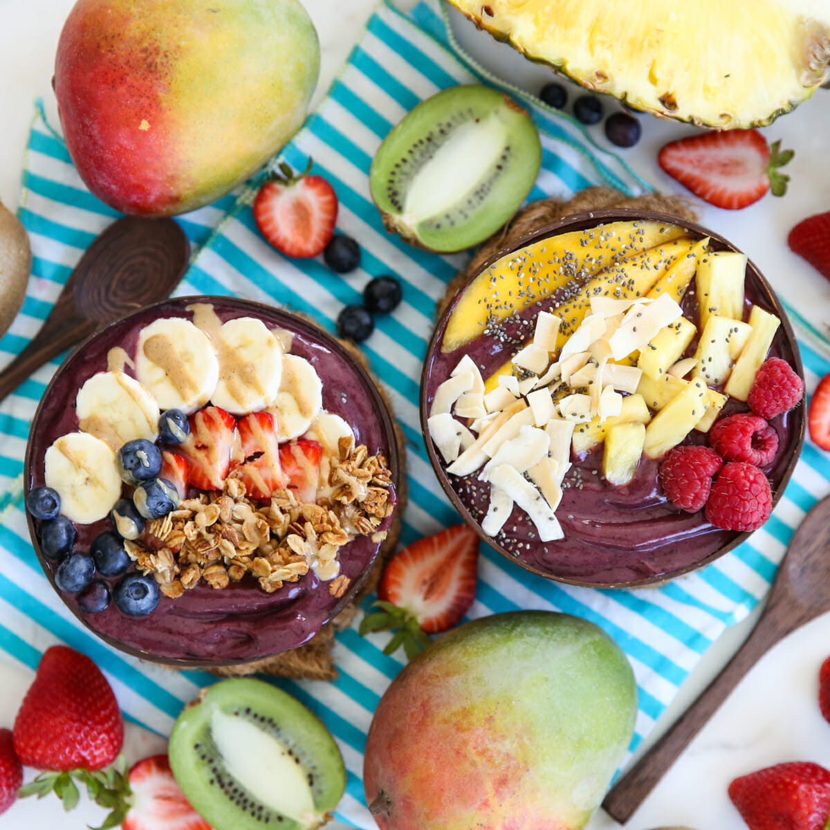 Two acai bowls, topped with fruit