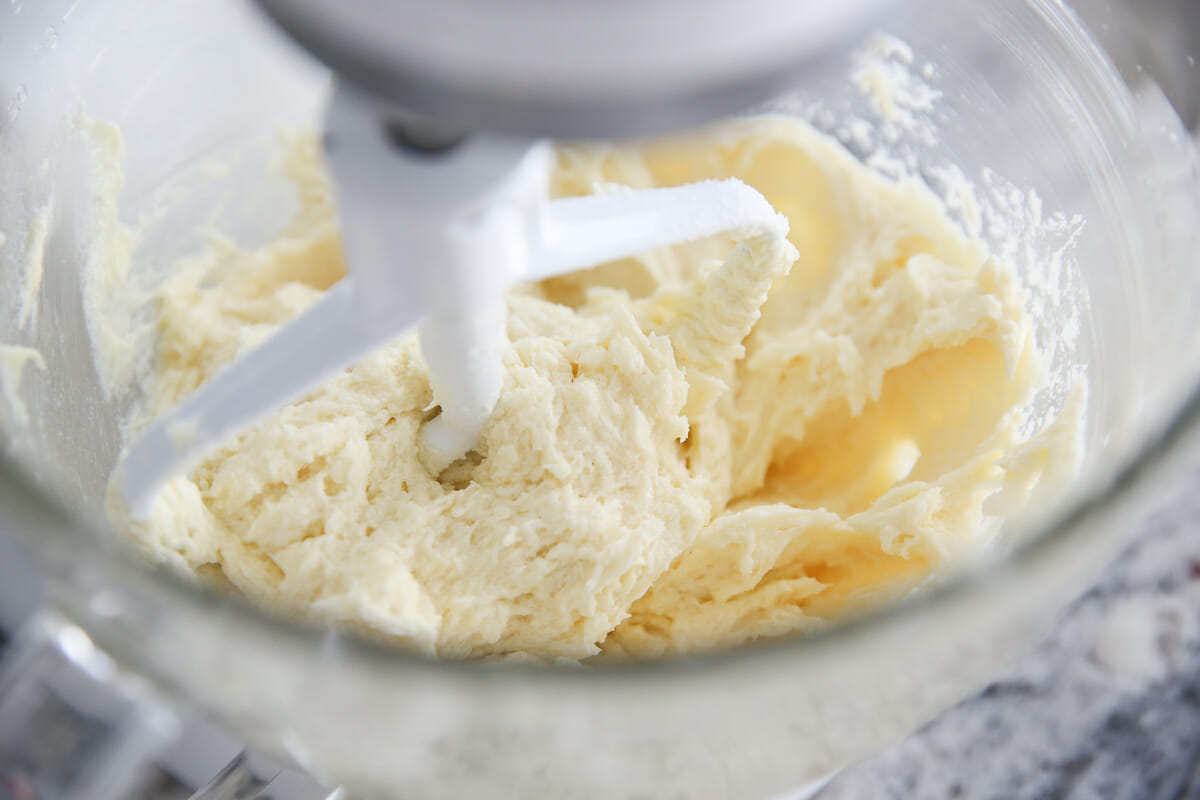 Butter and sugar being creamed together in a mixing bowl.